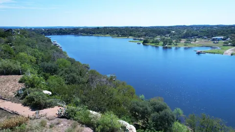an aerial view of residential houses with outdoor space and lake view