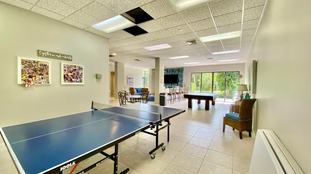 a dining room with furniture and a floor to ceiling window