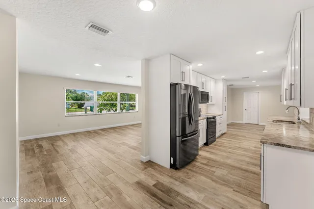 a kitchen with stainless steel appliances granite countertop a refrigerator and a sink