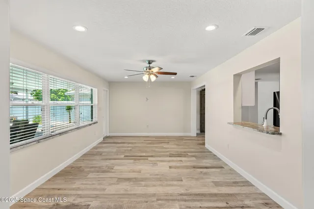 a view of a kitchen with wooden floor and a refrigerator