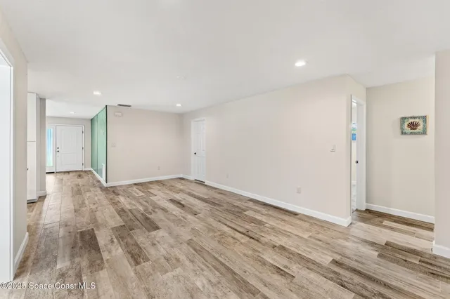 an empty room with windows and ceiling fan