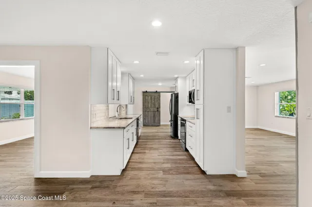 a view of a kitchen with refrigerator and a sink