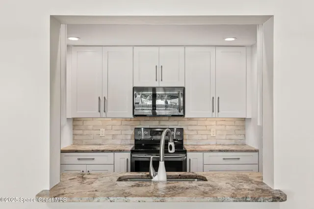 a kitchen with stainless steel appliances kitchen island sink refrigerator and stove