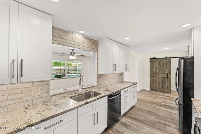 a large kitchen with granite countertop a sink and a refrigerator