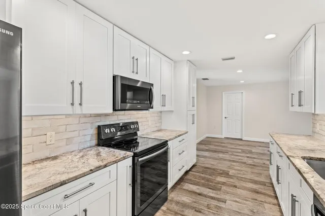 a kitchen with stainless steel appliances granite countertop a sink stove and microwave