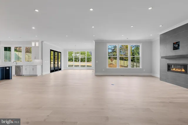 an empty room with windows and fireplace