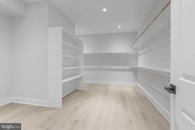 a view of an empty room with wooden floor and windows