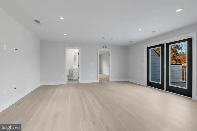 a view of an empty room with closet and windows
