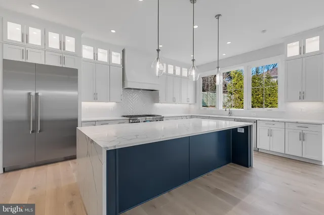 a kitchen with a sink a center island a stove and a wooden floor