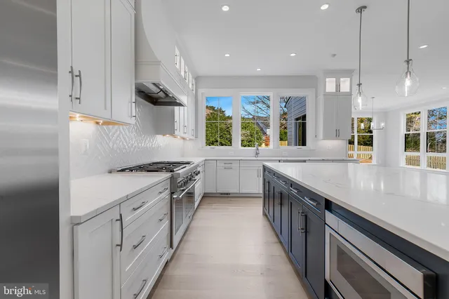 a kitchen with granite countertop a sink a counter space appliances and cabinets