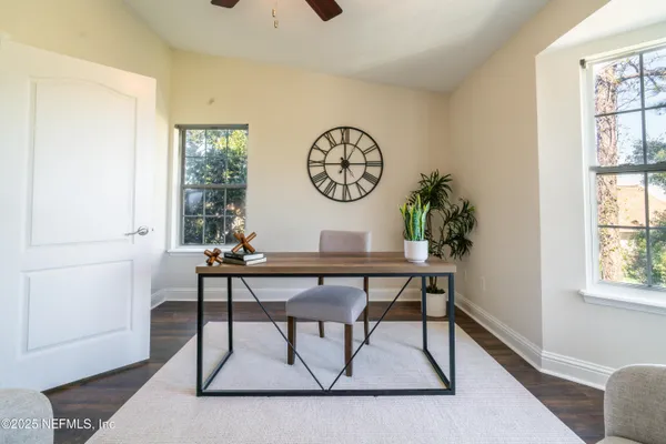 a view of empty room with wooden floor and fan