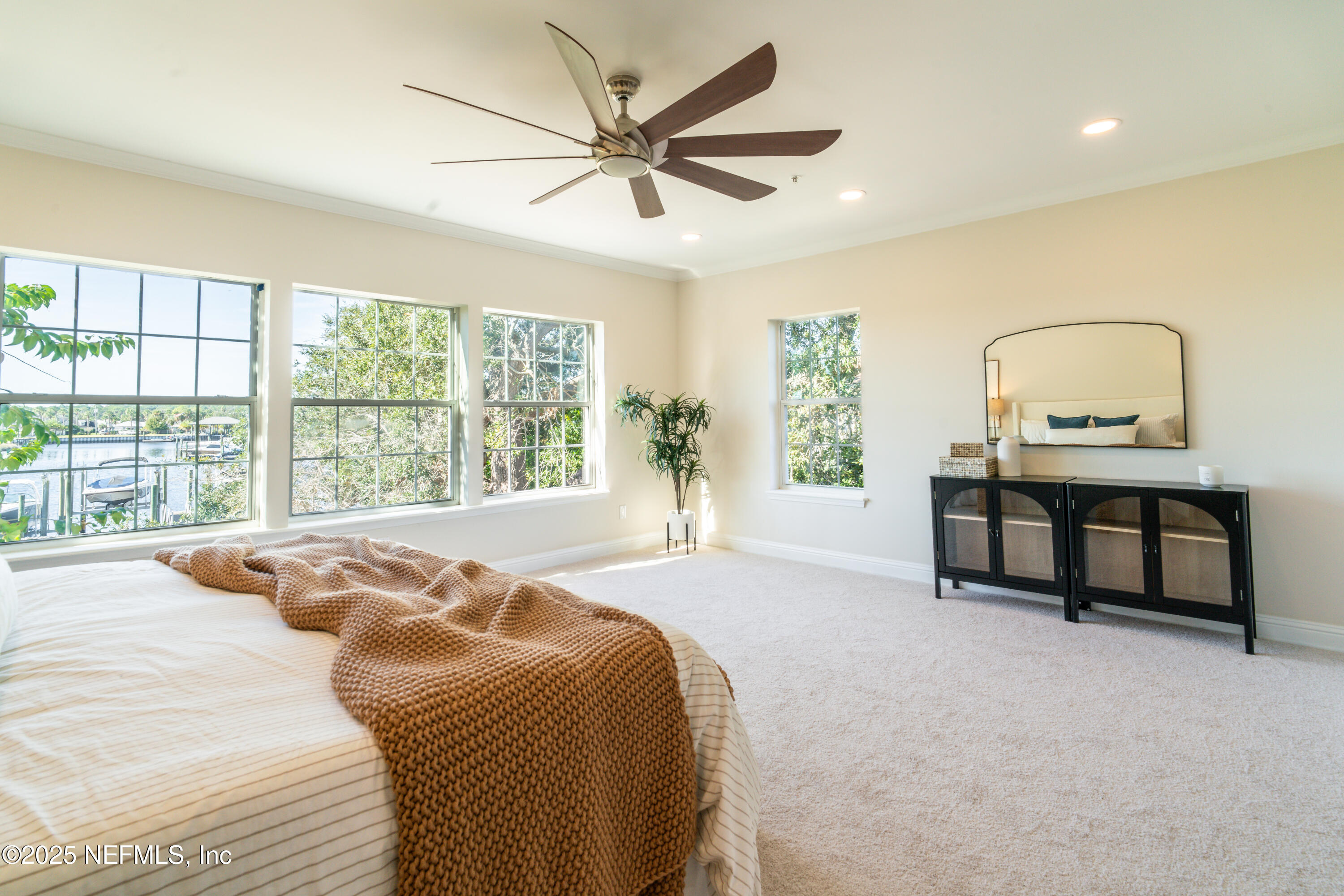 3360 Lighthouse Point Lane Jacksonville, FL 32250 - Photo 19 of 65 a spacious bedroom with a bed a window and a chandelier