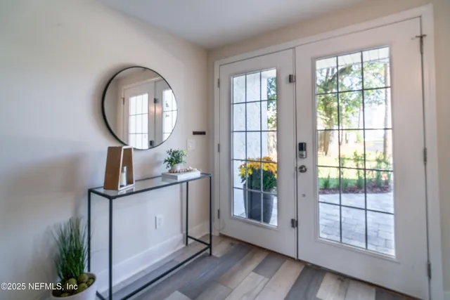 a living room with furniture a large window and stainless steel appliances