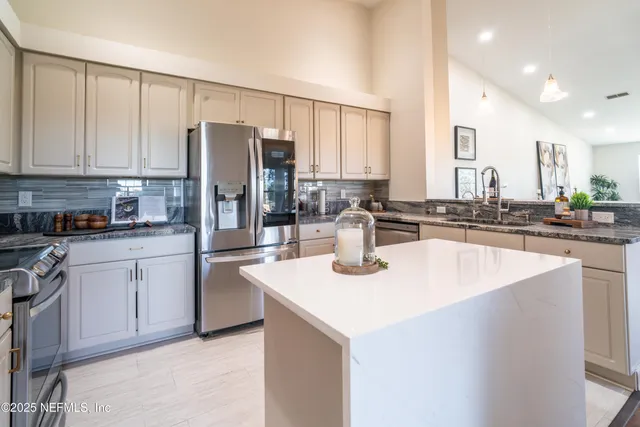 a large kitchen with kitchen island a sink stainless steel appliances and cabinets