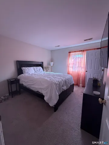a bedroom with a bed and a television