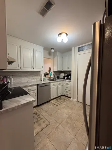 a kitchen with a refrigerator a sink and cabinets