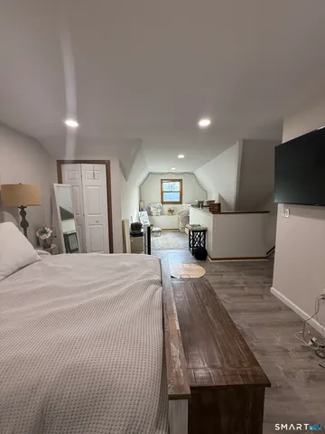 a large bedroom with a bed and a flat screen tv