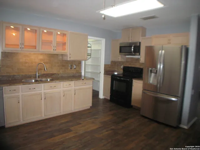 a kitchen with a refrigerator stove and sink