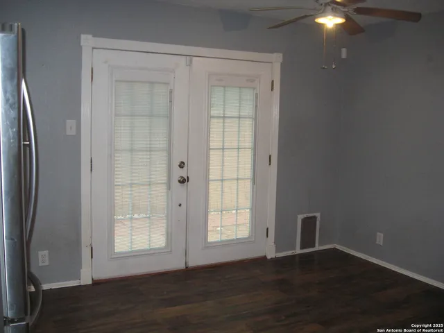 an empty room with wooden floor and windows