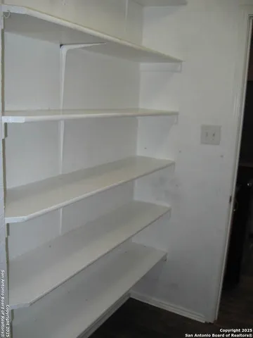 a view of walk in closet with empty racks
