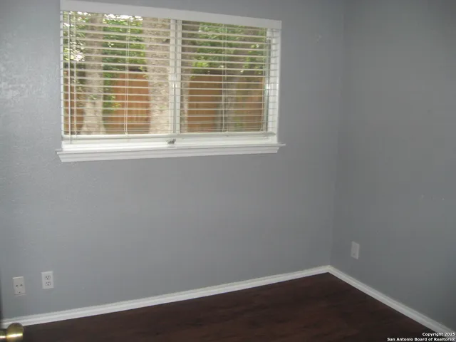 a view of a small space with wooden floor and a window
