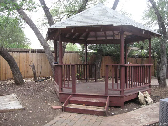 a view of backyard with a table and chairs under an umbrella