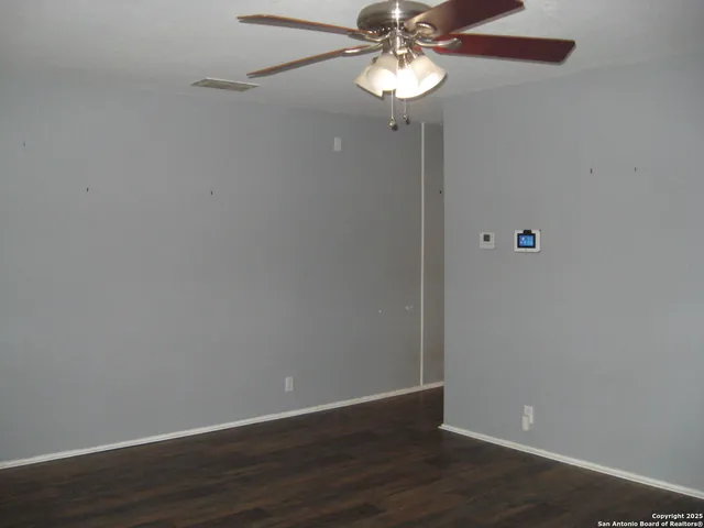 a view of an empty room with wooden floor