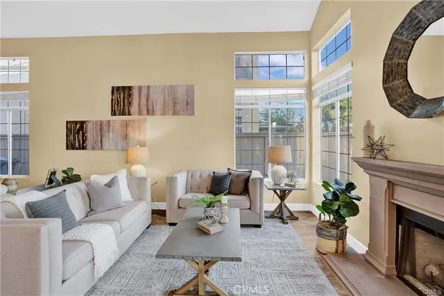 a living room with furniture a fireplace and a floor to ceiling window