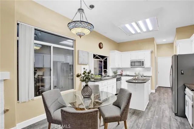a dining room with stainless steel appliances a table and chairs