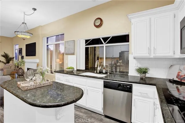 a kitchen with stainless steel appliances a sink a stove and white cabinets