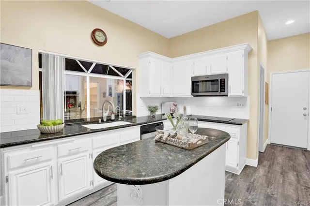 a kitchen with sink a microwave and cabinets