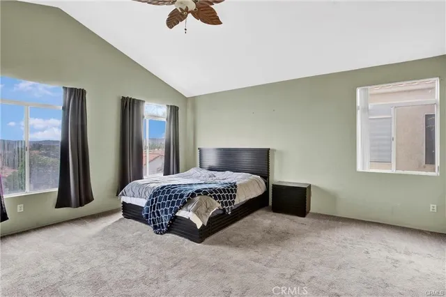 a spacious bedroom with a bed and glass walk in closet