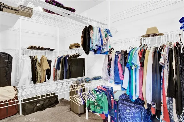 a view of walk in closet with clothes and shoes