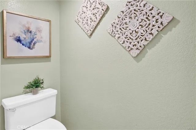 a white toilet sitting next to a white wall