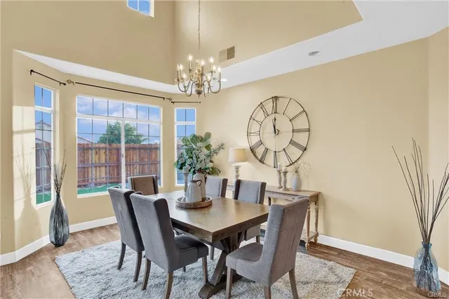 a view of a dining room with furniture a chandelier and wooden floor