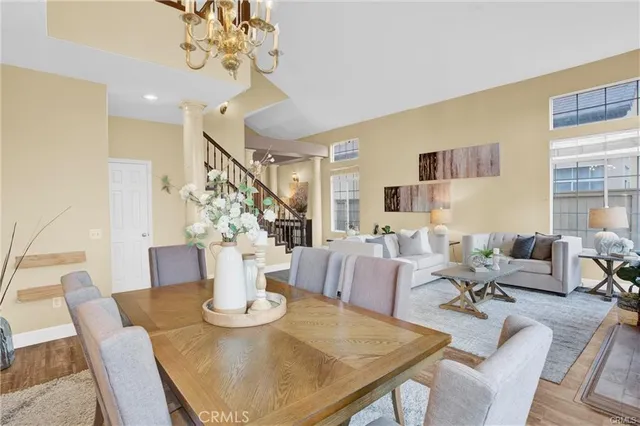 a view of a dining room with furniture a chandelier and wooden floor