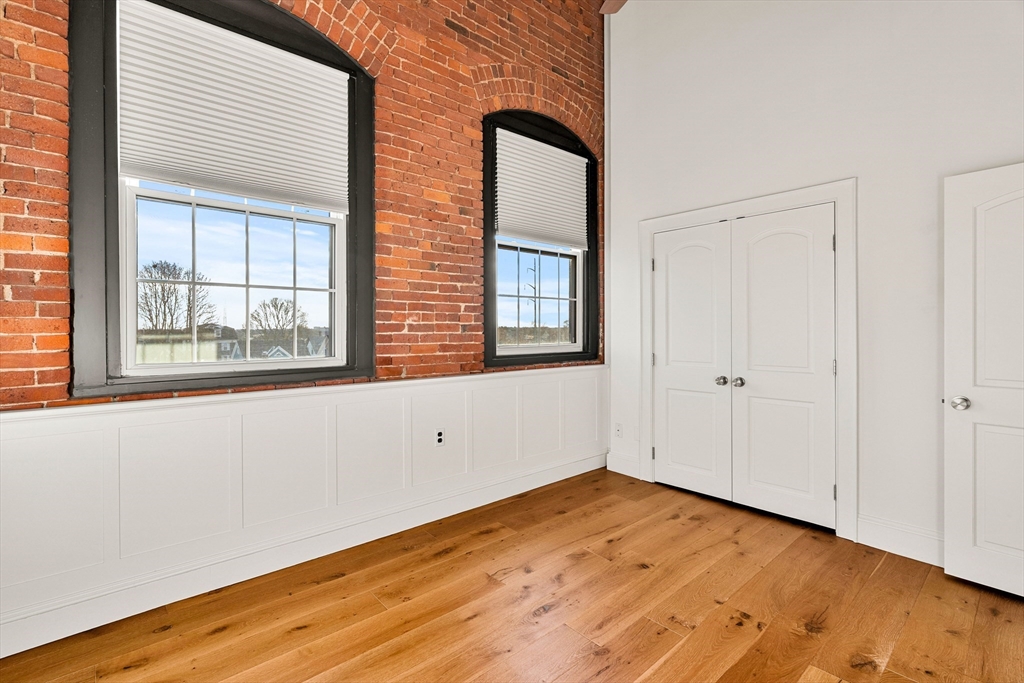 50 Rantoul Street, Unit 505 Beverly, MA 01915 - Photo 16 of 30 an empty room with wooden floor and windows