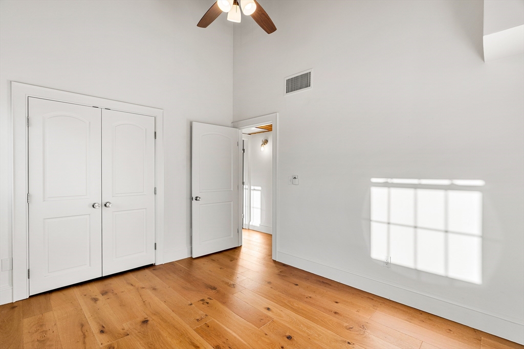 50 Rantoul Street, Unit 505 Beverly, MA 01915 - Photo 17 of 30 an empty room with wooden floor cabinet and windows