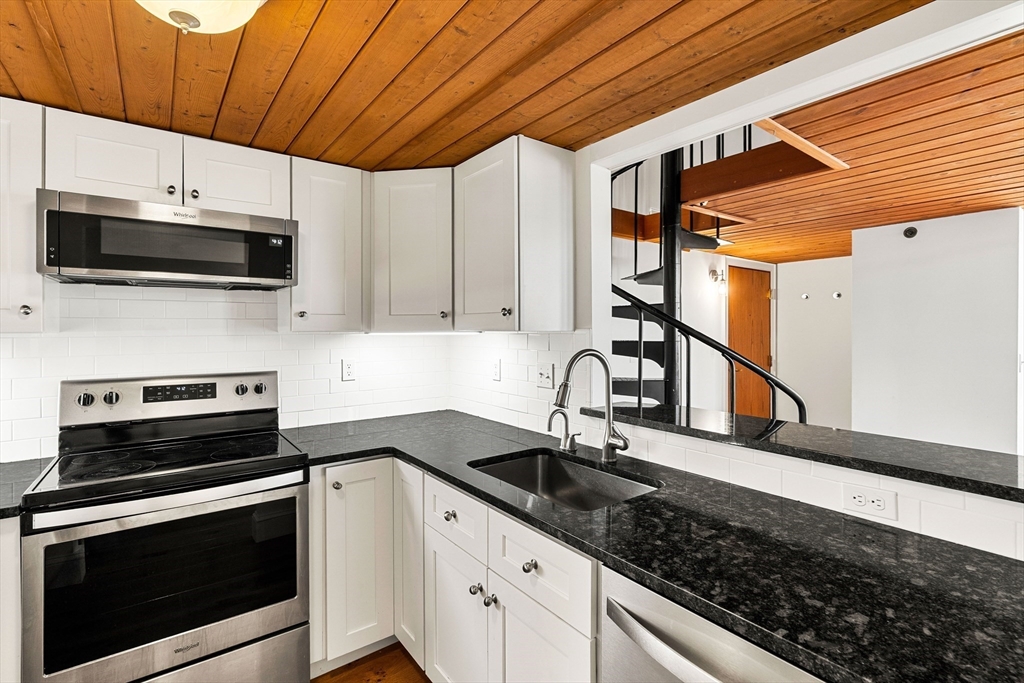50 Rantoul Street, Unit 505 Beverly, MA 01915 - Photo 7 of 30 a kitchen with stainless steel appliances a stove a sink a microwave and cabinets
