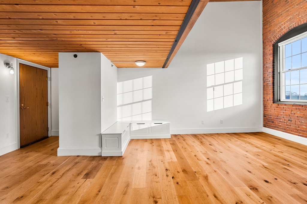 50 Rantoul Street, Unit 505 Beverly, MA 01915 - Photo 10 of 30 an empty room with wooden floor and windows