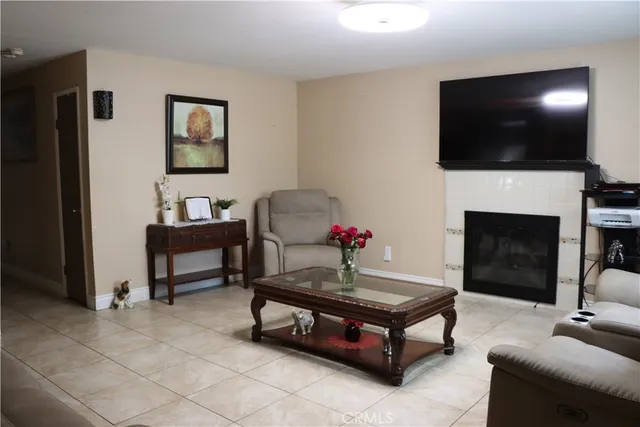 a living room with furniture a flat screen tv and a fireplace