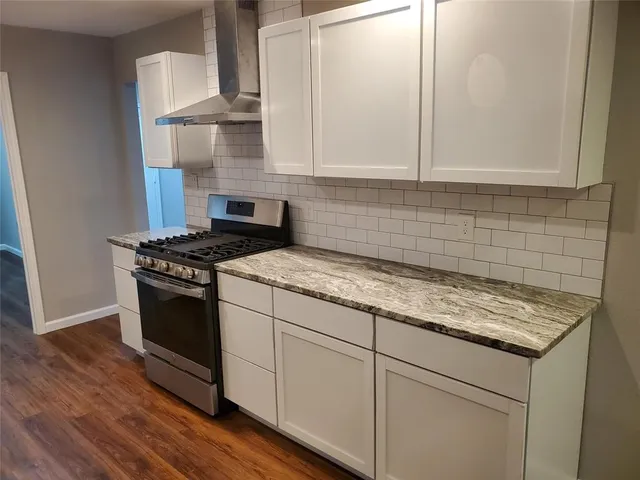 a kitchen with stainless steel appliances granite countertop a sink stove and cabinets