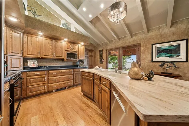 a kitchen with stainless steel appliances granite countertop a stove a sink and a refrigerator