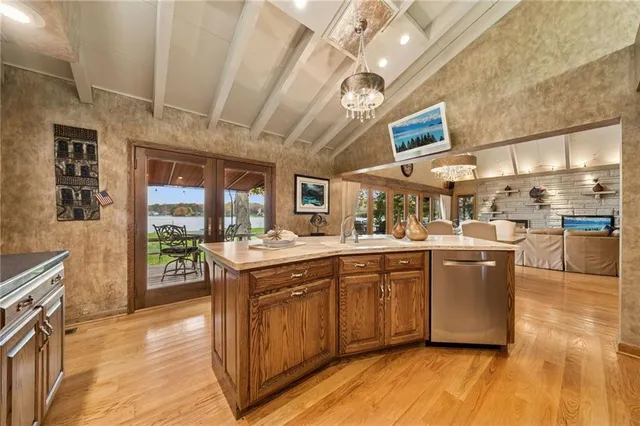 a kitchen with stainless steel appliances granite countertop a large stove a sink dishwasher and a refrigerator with wooden floor