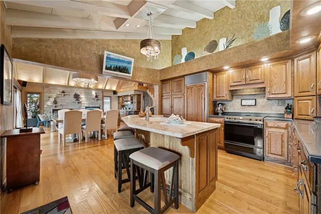 a kitchen with a stove a refrigerator and a dining table with wooden floor