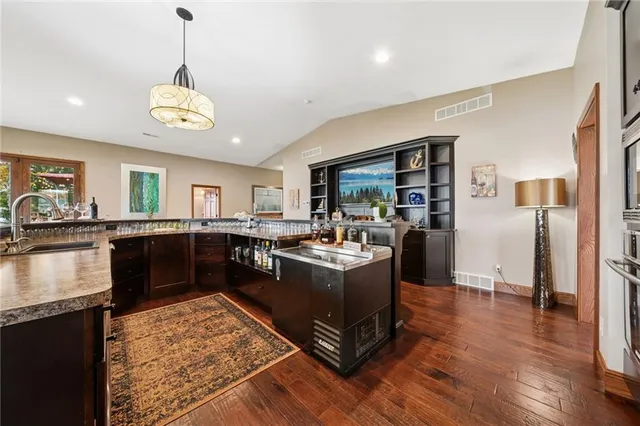 a living room with stainless steel appliances granite countertop furniture wooden floor and a large window