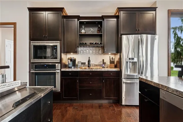 a kitchen with granite countertop a refrigerator stove and microwave