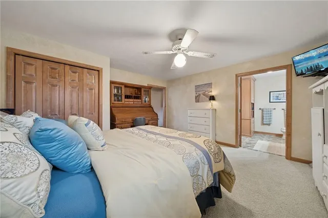 a spacious bedroom with a bed and a chandelier
