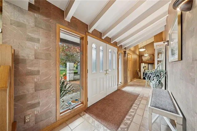 a hallway with a large stone wall and a large mirror