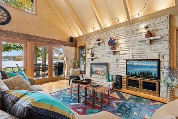a living room with furniture a fireplace and a floor to ceiling window